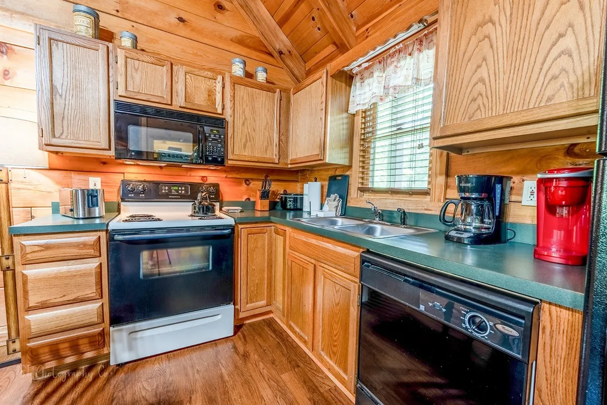 A close-up view of the kitchen area, featuring modern appliances, wooden cabinetry, and generous counter space. Natural light streams in from a nearby window, highlighting the warmth and cleanliness of the kitchen. Subtle details like a coffee maker and dish soap evoke a sense of readiness and convenience for meal preparation.